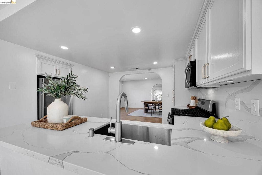 1509 Poppy Way, Antioch, CA 94509 Kitchen featuring white cabinetry, integrated stainless steel sink, pull-down faucet, recessed lighting, and stone-finish countertops