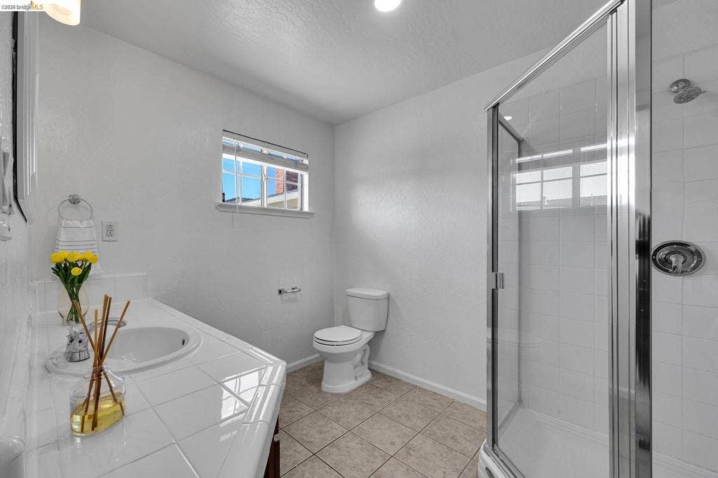 1509 Poppy Way, Antioch, CA 94509 Full bathroom with a tiled vanity, integrated sink, and a glass-enclosed shower with a tiled surround