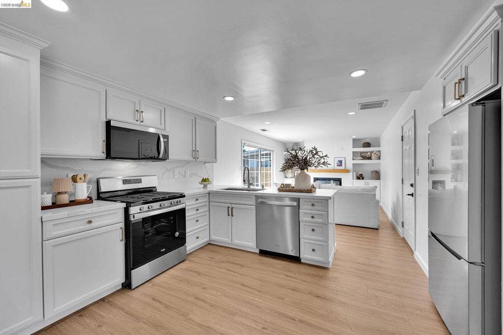 1509 Poppy Way, Antioch, CA 94509 Modern kitchen featuring white shaker cabinetry, stainless steel appliances, a white backsplash, light wood-finish flooring, and recessed lighting