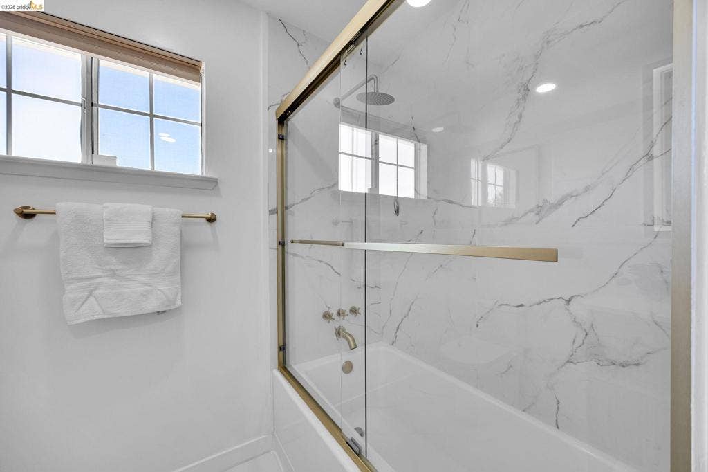1509 Poppy Way, Antioch, CA 94509 Tub and shower combination featuring gold-finish fixtures and clear glass sliding doors