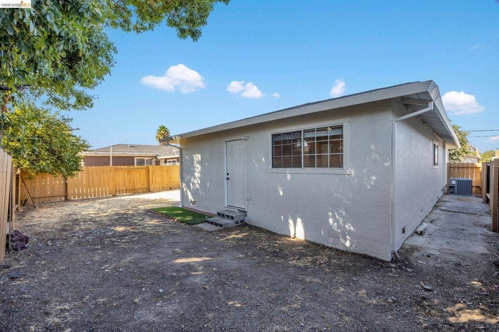 1509 Poppy Way, Antioch, CA 94509 Exterior building with white stucco siding, multi-pane windows, and a side-entry door