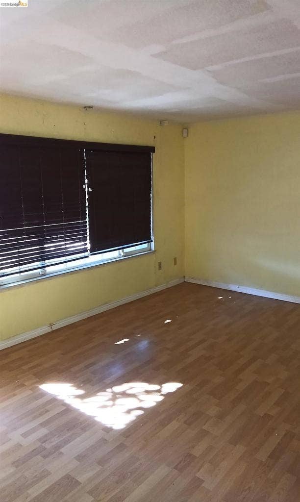 145 Viking Way, Pittsburg, CA 94565 Wood-finish flooring with a window featuring dark blinds