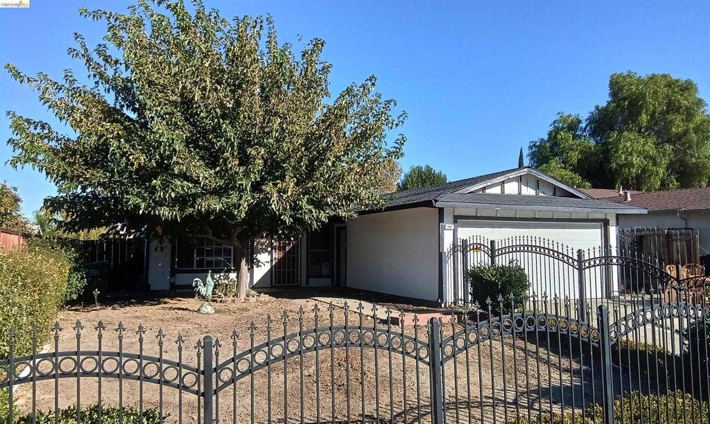 145 Viking Way, Pittsburg, CA 94565 Decorative wrought iron fencing, mature front yard tree, attached garage, composition shingle roof, and stucco exterior