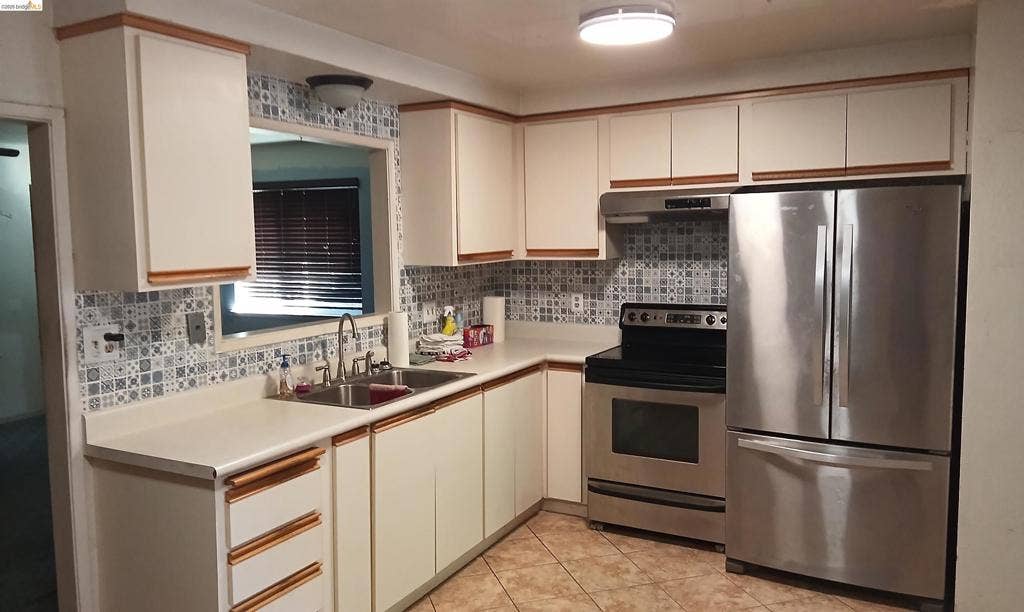 145 Viking Way, Pittsburg, CA 94565 Kitchen featuring stainless steel appliances, patterned tile backsplash, dual basin stainless steel sink, wood-finish cabinetry, and overhead flush mount lighting