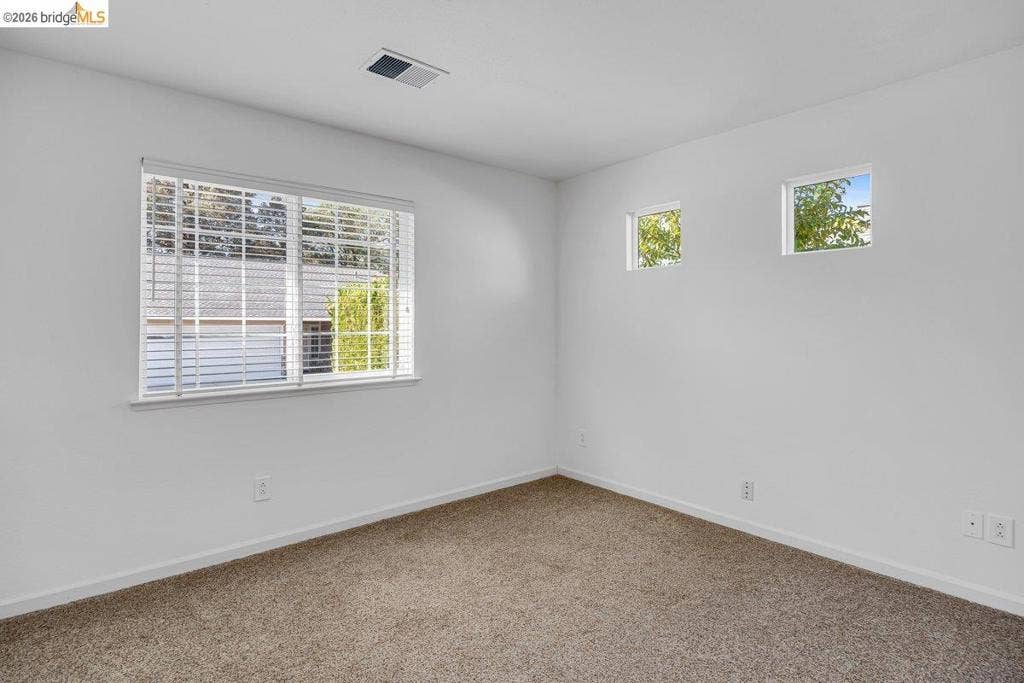 981 Country Ln, Angels Camp, CA 95222 Carpeted flooring, white walls, large window with blinds, two smaller windows