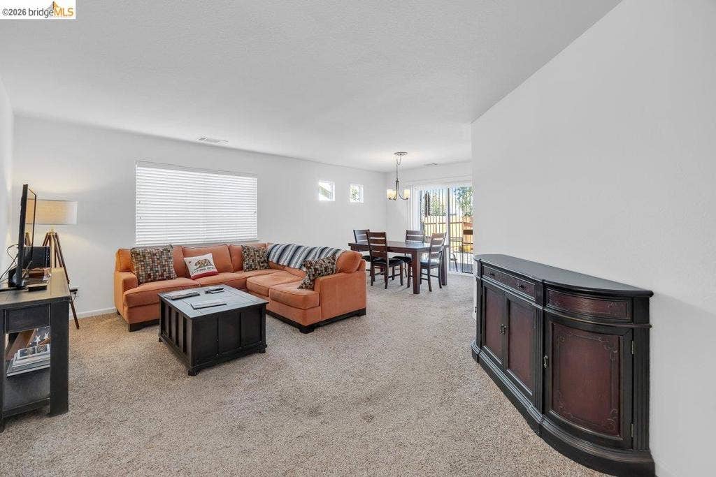 981 Country Ln, Angels Camp, CA 95222 Carpeted living area with a large window and white blinds