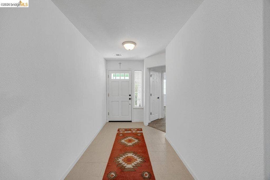 981 Country Ln, Angels Camp, CA 95222 White paneled entry door with decorative glass, sidelight, ceiling-mounted light fixture, and neutral tile flooring