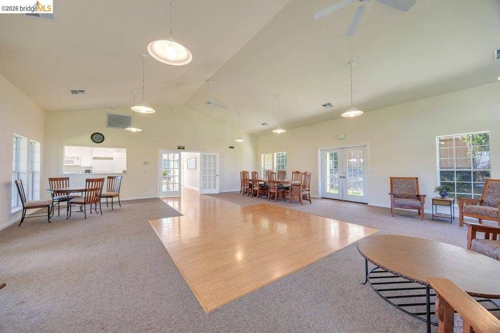 981 Country Ln, Angels Camp, CA 95222 Vaulted ceiling with ceiling fans, recessed lighting, expansive carpeted flooring, wood-finish flooring area, and multiple windows