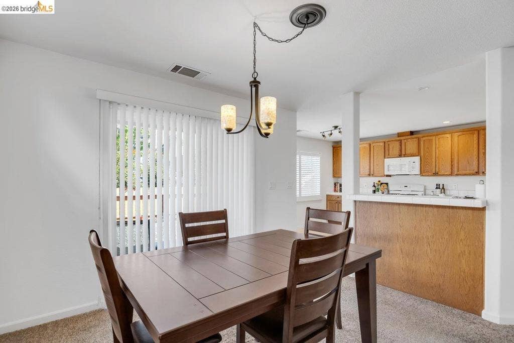 981 Country Ln, Angels Camp, CA 95222 Recessed lighting, wood-finish cabinetry, white appliances, and a breakfast bar