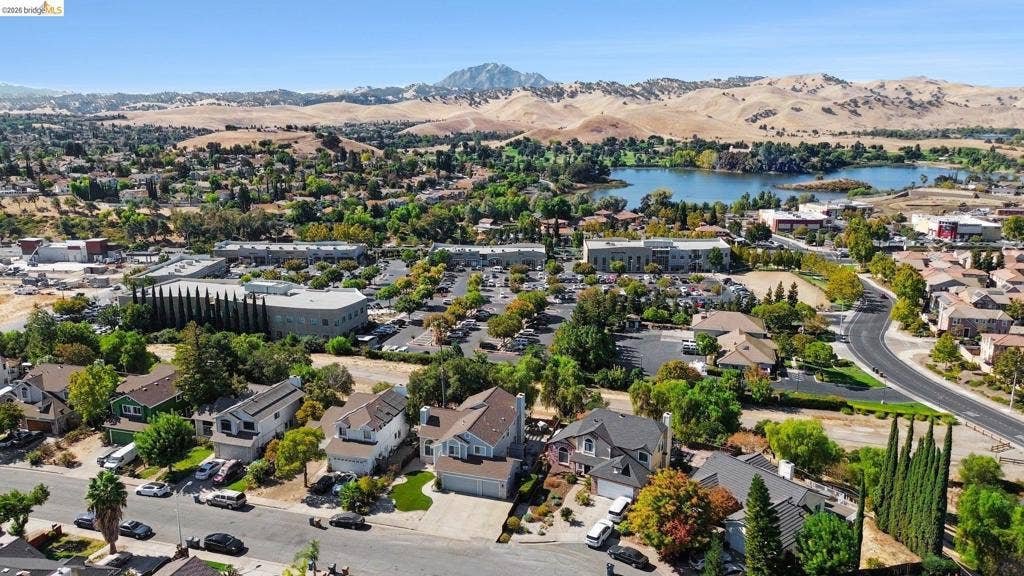 304 Greystone Dr, Antioch, CA 94509 Aerial perspective featuring proximity to a lake, surrounding rolling hills, expansive mature tree canopy, and established residential streets