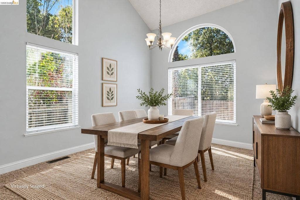 304 Greystone Dr, Antioch, CA 94509 Vaulted ceilings featuring a multi-arm chandelier, large arched window, and additional tiered windows