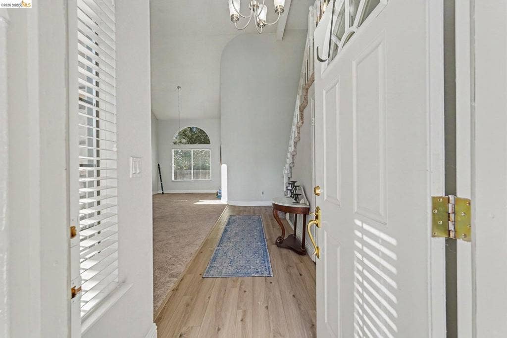 304 Greystone Dr, Antioch, CA 94509 Entryway featuring wood-finish flooring, vaulted ceilings, arched window detailing, and a multi-pane glass insert door