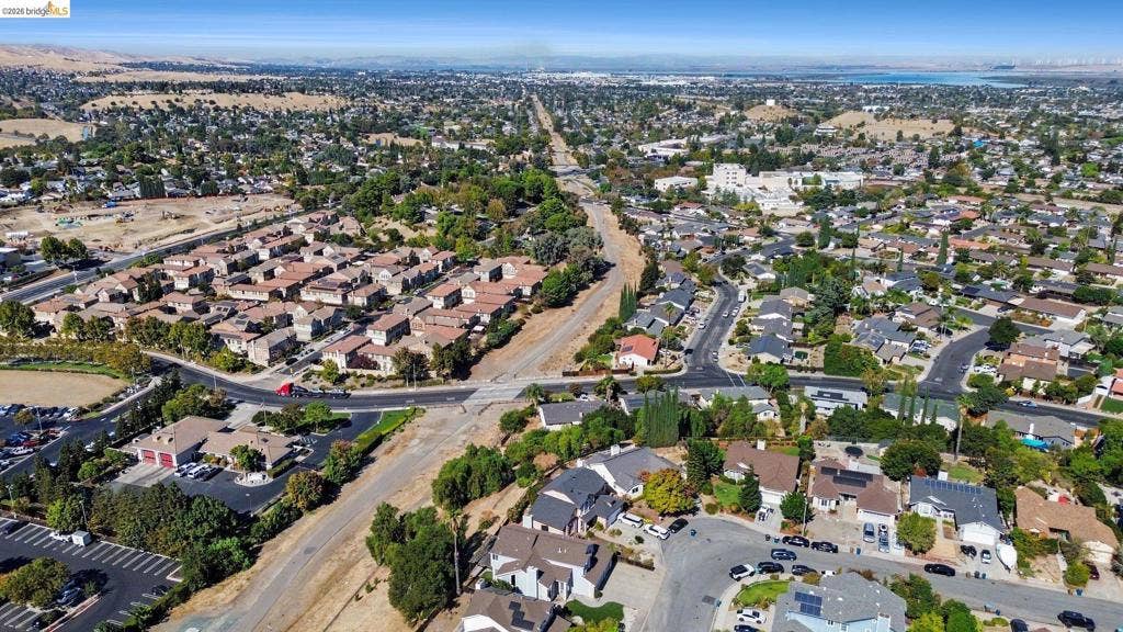 304 Greystone Dr, Antioch, CA 94509 Aerial perspective of a suburban neighborhood featuring paved street infrastructure, multi-level residential structures with pitched roofs, mature trees, and established landscape density