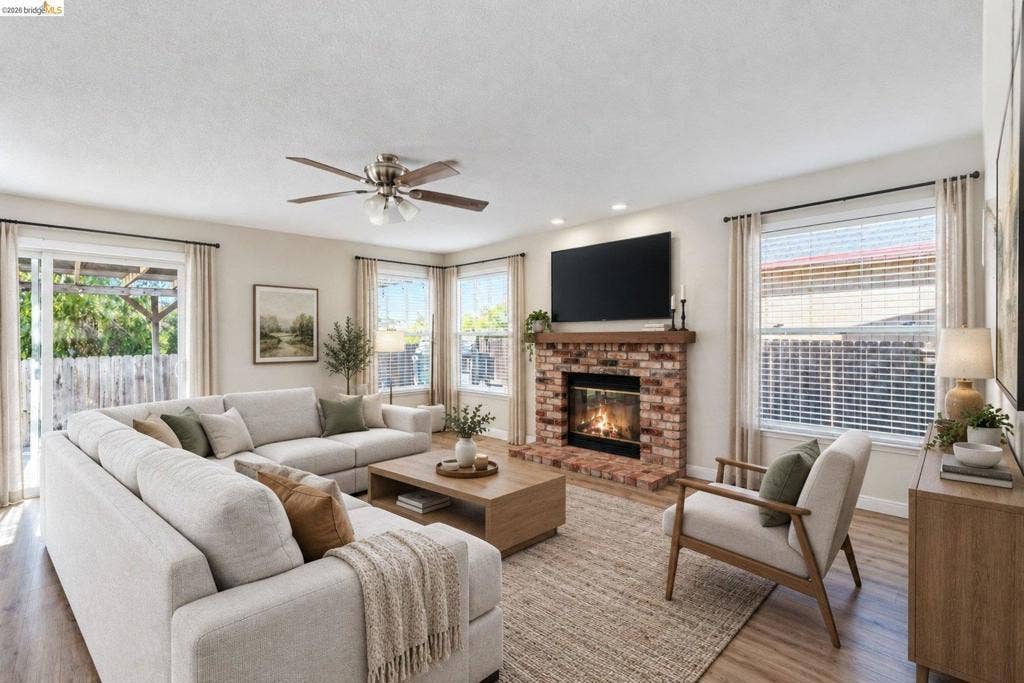 304 Greystone Dr, Antioch, CA 94509 Living room featuring a floor-to-ceiling brick fireplace with a wood mantel, wood-finish flooring, recessed lighting, and a ceiling fan