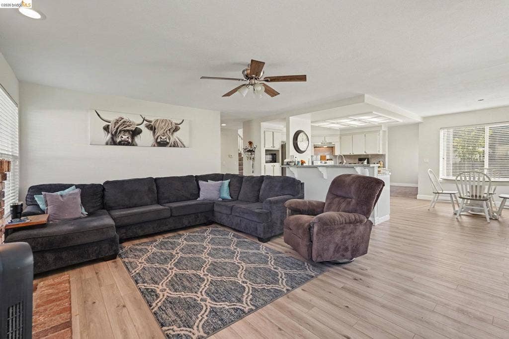 304 Greystone Dr, Antioch, CA 94509 Open-concept interior featuring light wood-finish flooring, recessed lighting, a ceiling fan with integrated lighting, and a kitchen breakfast bar with overhead soffit lighting