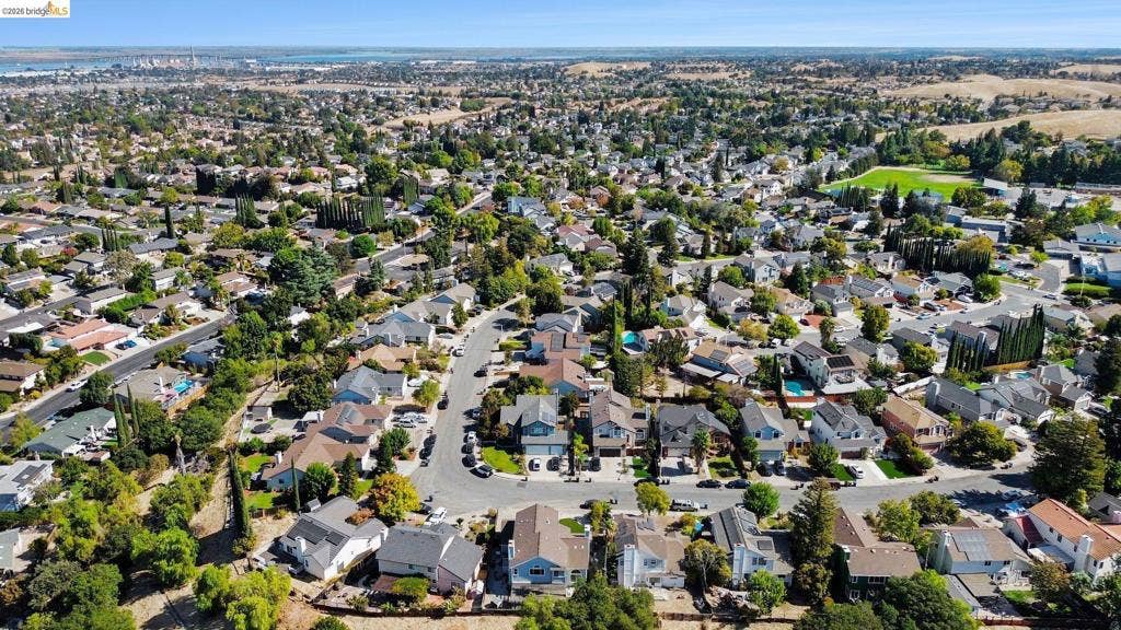 304 Greystone Dr, Antioch, CA 94509 Aerial perspective of a residential neighborhood featuring mature tree-lined streets, diverse housing architecture, and proximity to expansive open space