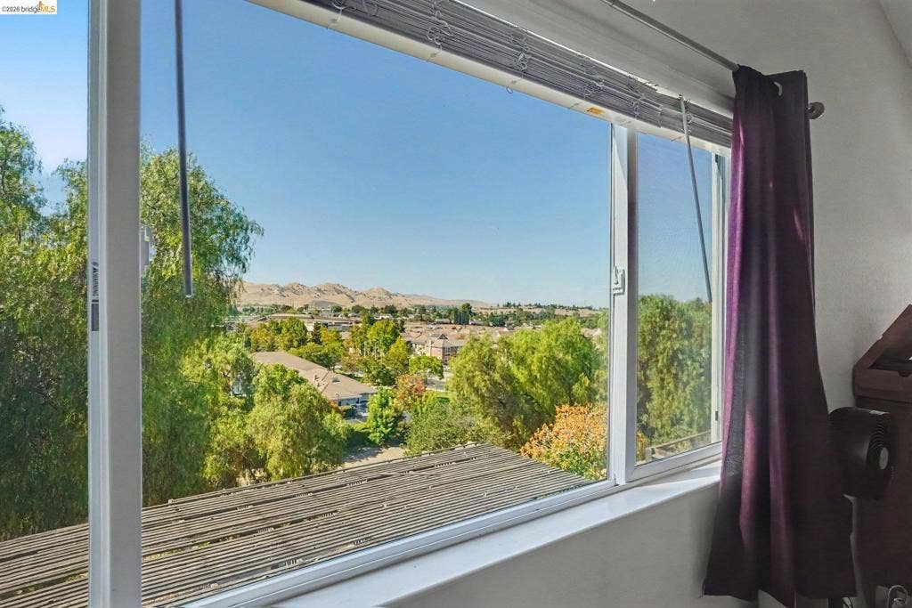 304 Greystone Dr, Antioch, CA 94509 Large horizontal sliding window featuring a white frame and extensive scenery of mountainous terrain and mature greenery