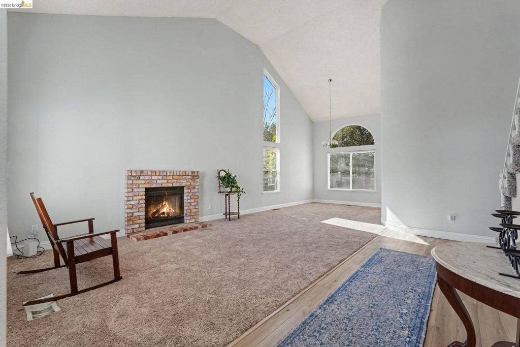 304 Greystone Dr, Antioch, CA 94509 Vaulted ceilings, multi-level brick fireplace, stacked vertical windows, arched window, and wood-finish flooring