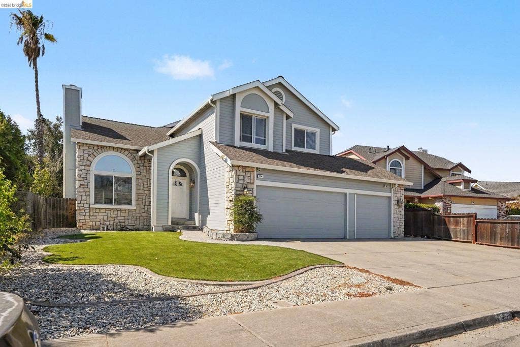 304 Greystone Dr, Antioch, CA 94509 Two-story exterior featuring stone veneer siding, arched window detailing, an attached multi-car garage, and a manicured front lawn