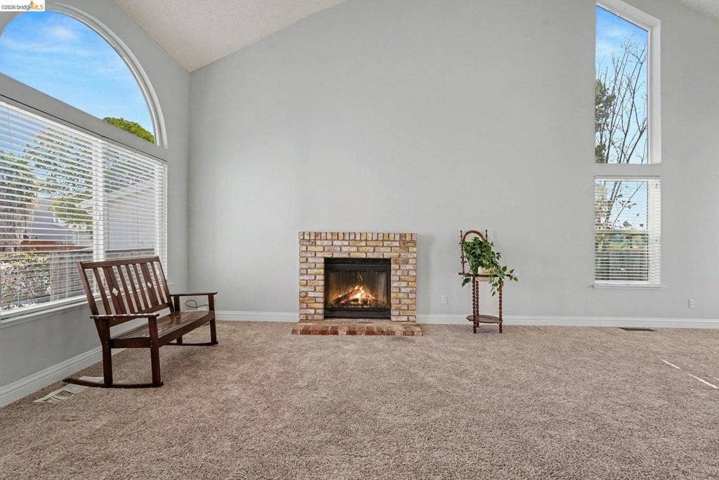 304 Greystone Dr, Antioch, CA 94509 Vaulted ceilings, brick fireplace, and tall arched windows with natural light
