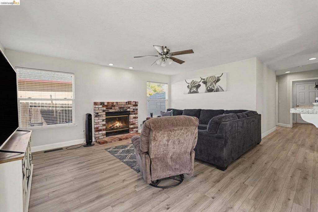 304 Greystone Dr, Antioch, CA 94509 Living area featuring wood-finish flooring, a brick-surround fireplace with a mantel, recessed lighting, and a ceiling fan