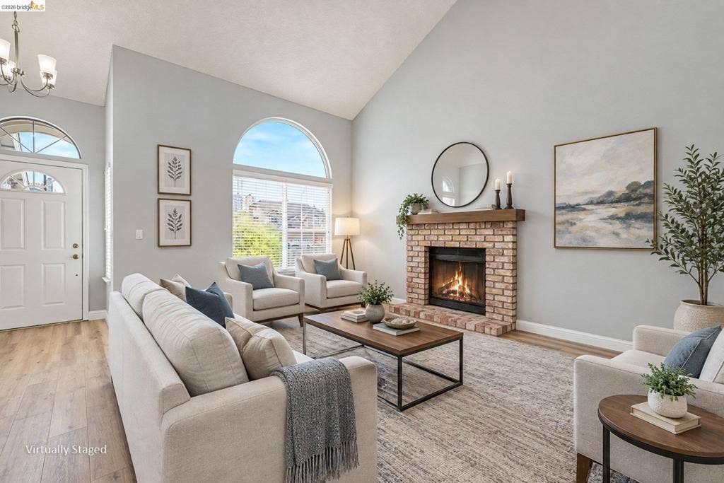 304 Greystone Dr, Antioch, CA 94509 Vaulted ceilings, brick fireplace with a wood mantel, arched windows, wood-finish flooring, and multi-pane entry door