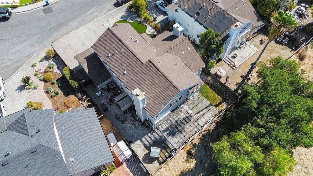 304 Greystone Dr, Antioch, CA 94509 Aerial perspective of a multi-level residence featuring a composition shingle roof, chimney stack, rear pergola, concrete patio, and private driveway