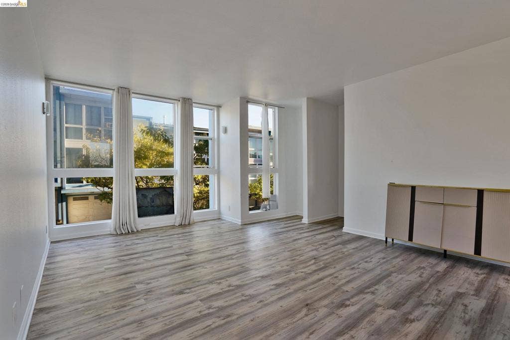 Expansive interior space featuring floor-to-ceiling windows, wood-finish flooring, and built-in cabinetry
