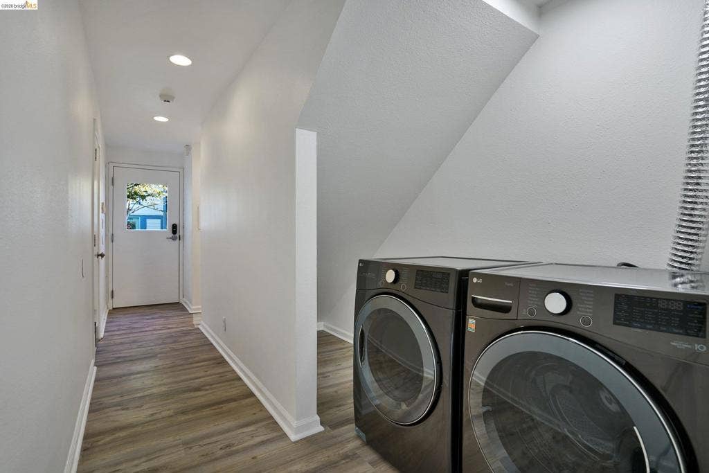 Laundry area featuring recessed ceiling lighting, wood-finish flooring, and an exterior door with a glass panel