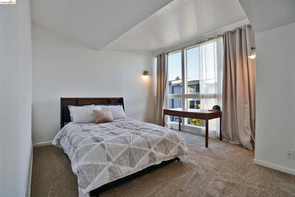 Vaulted ceilings, expansive floor-to-ceiling windows, and wall-mounted sconce lighting