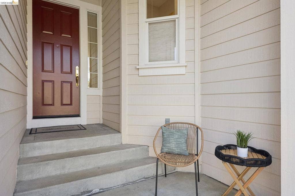 5503 Rainbow Cir, Santa Rosa, CA 95409 Covered entryway featuring horizontal lap siding, a paneled door with glass side light, and concrete stairs