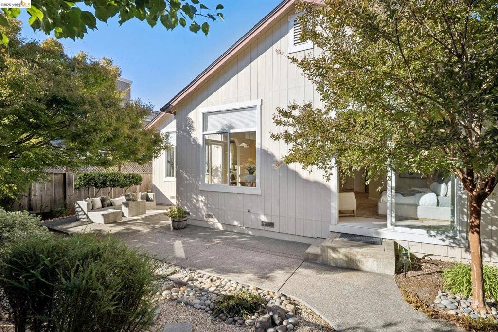 5503 Rainbow Cir, Santa Rosa, CA 95409 Exterior featuring vertical siding, concrete hardscaping, stone-accented landscaping, and large windows