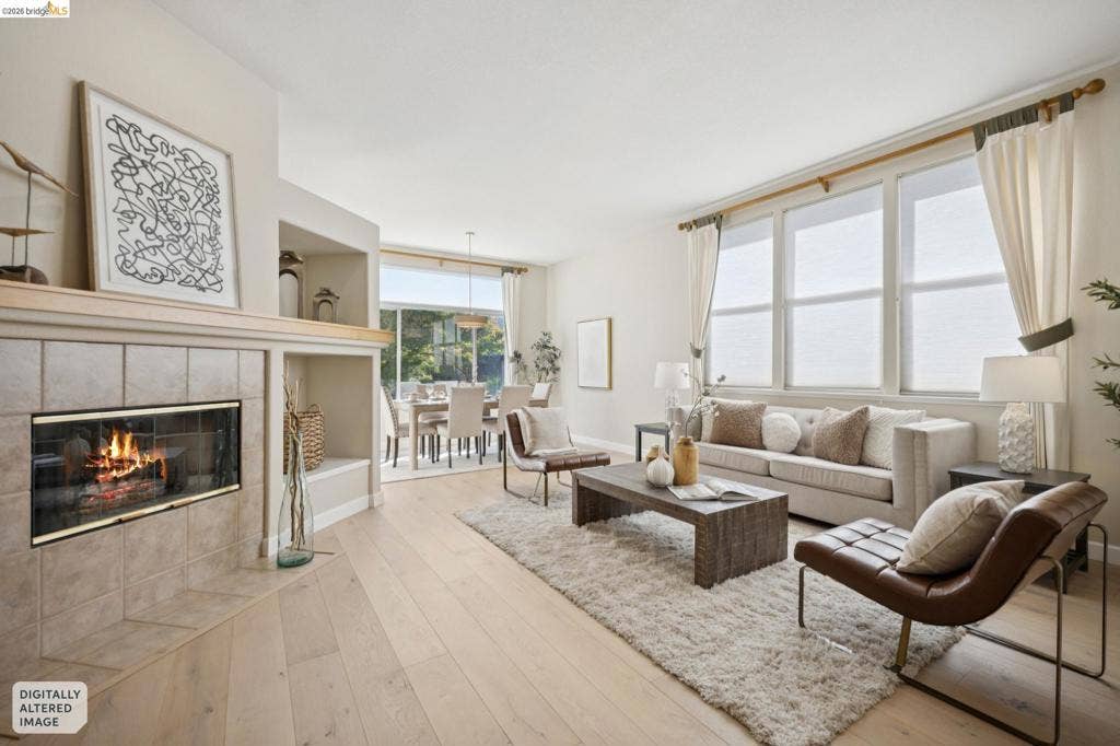 5503 Rainbow Cir, Santa Rosa, CA 95409 Fireplace with neutral ceramic tile surround, integrated shelving, light wood-finish flooring, and expansive multi-pane windows