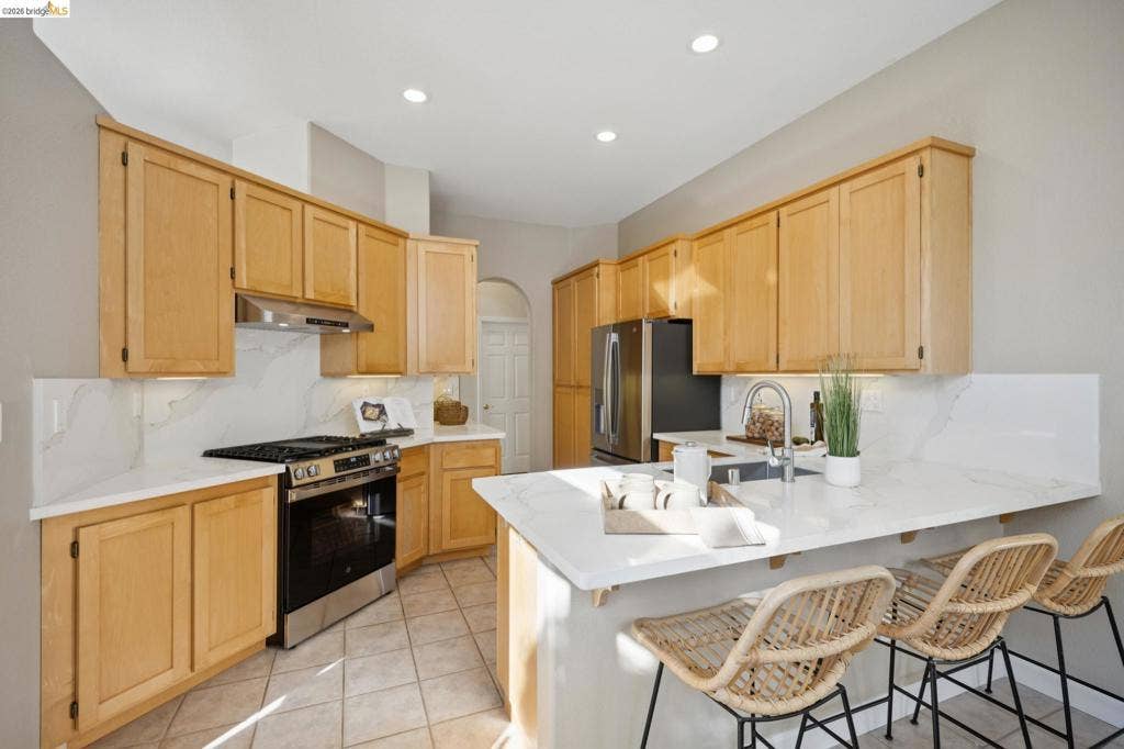 5503 Rainbow Cir, Santa Rosa, CA 95409 Kitchen featuring light wood cabinetry, white stone-finish countertops, stainless steel appliances, a tile backsplash, and recessed lighting