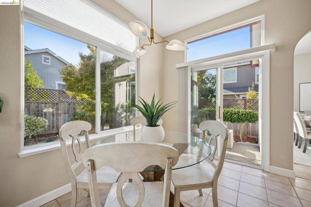 5503 Rainbow Cir, Santa Rosa, CA 95409 Large windows, sliding glass door, multi-arm metal chandelier, and ceramic tile flooring