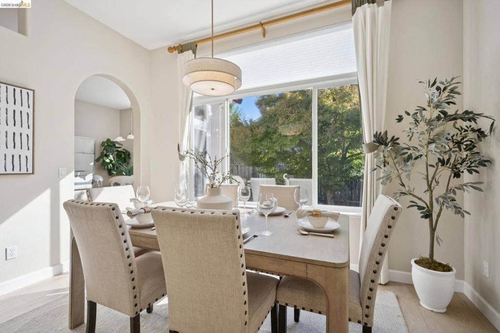 5503 Rainbow Cir, Santa Rosa, CA 95409 Large picture window with horizontal transom, architectural arched doorway, drum pendant light fixture, and wood-finish flooring