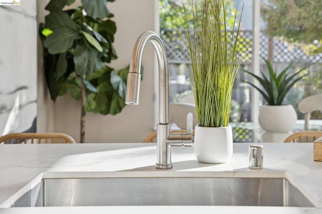5503 Rainbow Cir, Santa Rosa, CA 95409 Undermount stainless steel sink featuring a high-arc brushed nickel pull-down faucet and a stone-surface countertop