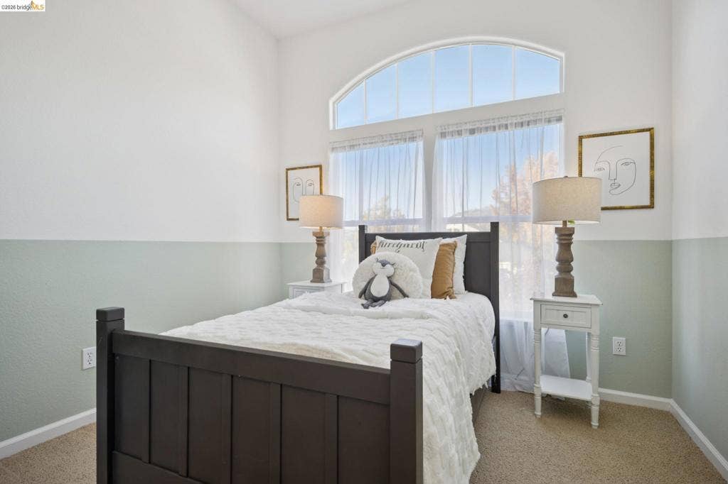 5503 Rainbow Cir, Santa Rosa, CA 95409 Vaulted ceiling featuring an arched window, neutral wall-to-wall carpeting, and two-toned wall paint