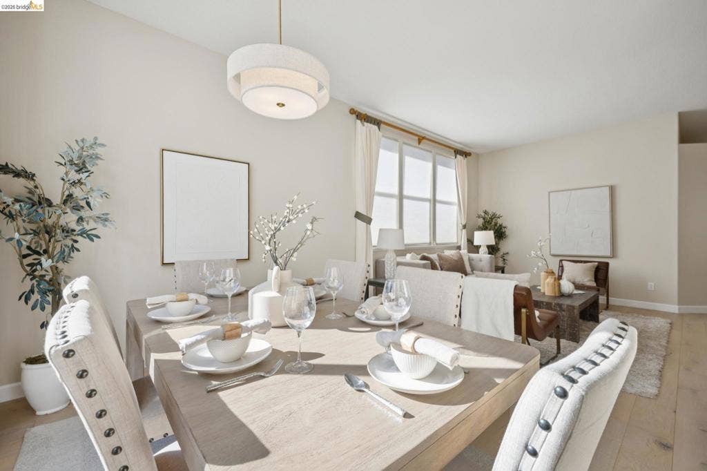 5503 Rainbow Cir, Santa Rosa, CA 95409 Open-concept area featuring light-toned wood-finish flooring, large multi-pane windows, and a modern drum-style pendant light fixture