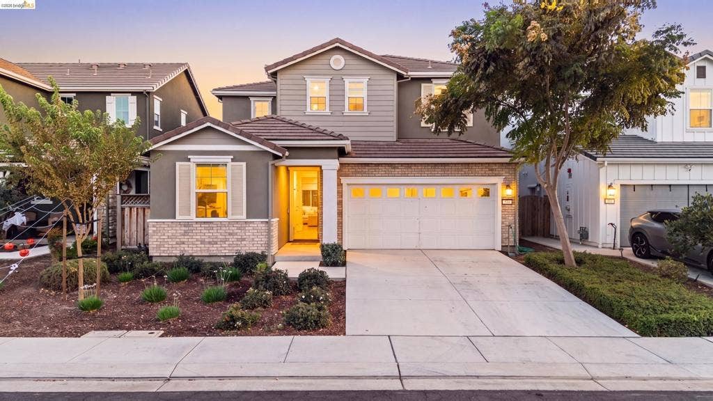 539 Gemstone Way, Oakley, CA 94561 Two-story residence featuring horizontal siding, brick veneer detailing, a multi-car garage, and a concrete driveway