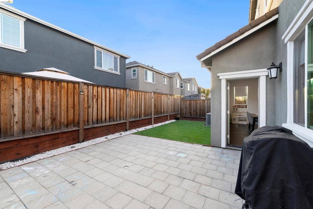 539 Gemstone Way, Oakley, CA 94561 Private rear yard featuring a paved patio, grass lawn, wood fencing, and an attached exterior light fixture