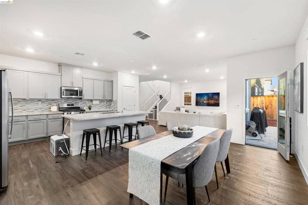 539 Gemstone Way, Oakley, CA 94561 Open-concept interior featuring light gray cabinetry, stone-finish countertops, recessed lighting, wood-finish flooring, and a glass-paned door
