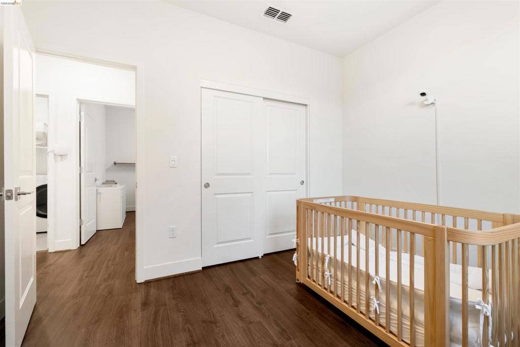 539 Gemstone Way, Oakley, CA 94561 Room featuring wood-finish flooring, white walls, and a sliding-door closet with recessed paneling