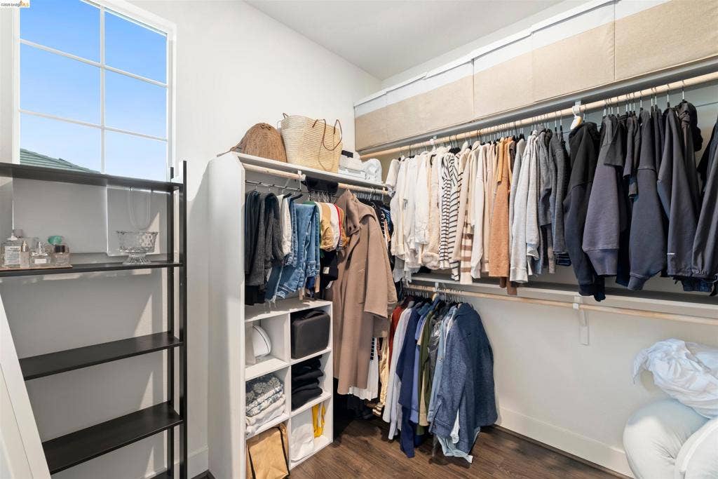 539 Gemstone Way, Oakley, CA 94561 Walk-in closet featuring multi-tiered hanging rods, built-in cubby shelving, wood-finish flooring, and a multi-pane window