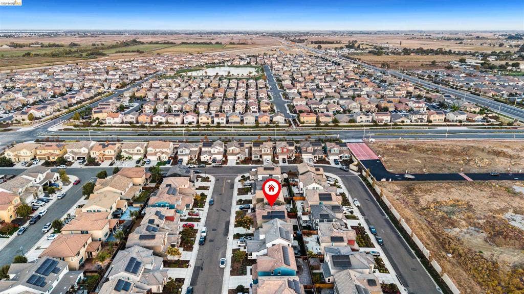 539 Gemstone Way, Oakley, CA 94561 Aerial view of a residential property featuring a pitched roof, integrated solar panels, a paved driveway, and a fenced backyard