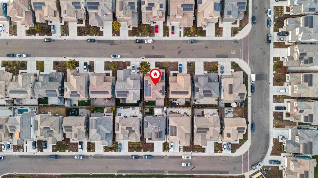 539 Gemstone Way, Oakley, CA 94561 Aerial perspective of a residential property featuring solar panel arrays, a multi-pitched roofline, an attached garage, and a private rear hardscape