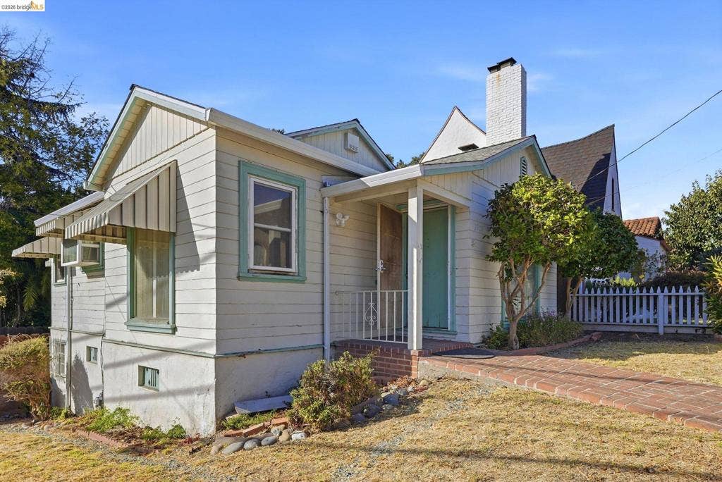 2901 Sheffield Ave, Oakland, CA 94602 Exterior featuring horizontal siding, a covered entry porch with metal railing, a brick walkway, and a masonry chimney
