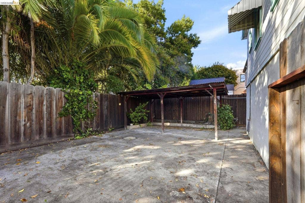 2901 Sheffield Ave, Oakland, CA 94602 Concrete patio area featuring a covered structure, enclosed by perimeter wood fencing and mature vegetation