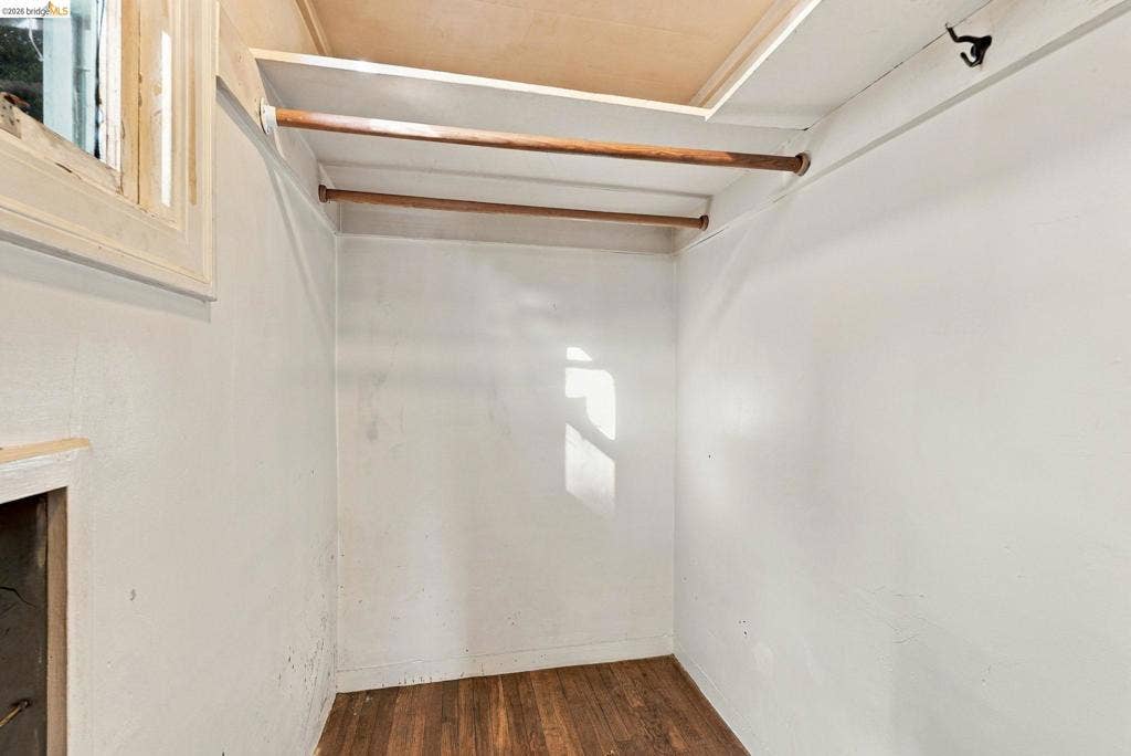 2901 Sheffield Ave, Oakland, CA 94602 Storage space featuring dual wood-finish hanging rods, integrated shelving, and wood-finish flooring