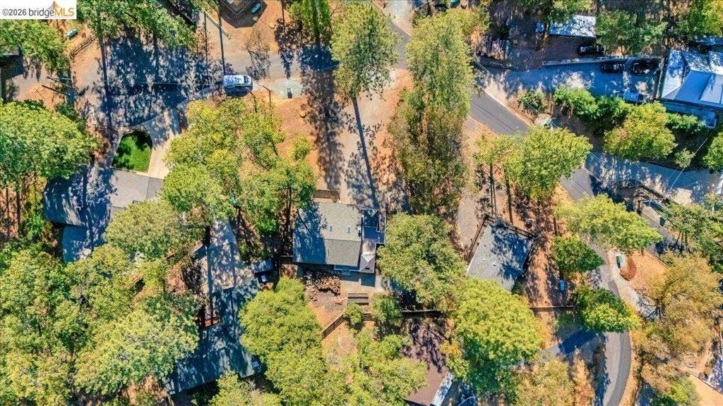 5827 Lookout Ct, CA 95233 Aerial perspective of a multi-structure property featuring pitched roofing and extensive mature tree canopy
